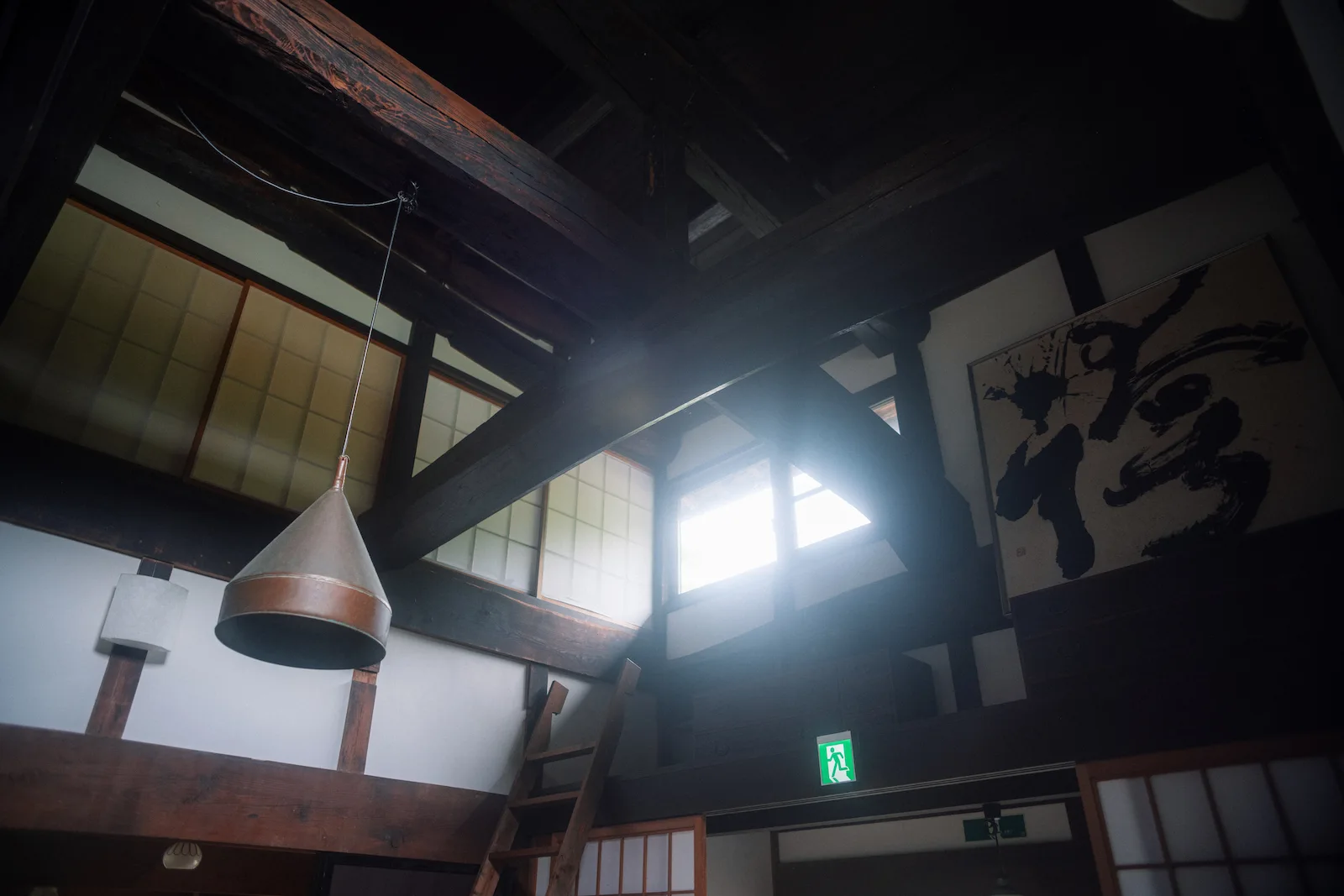 天窓から光が差し込む吹き抜けの梁